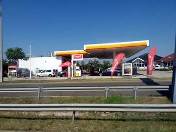 A busy Shell petrol station with a car wash and convenience store